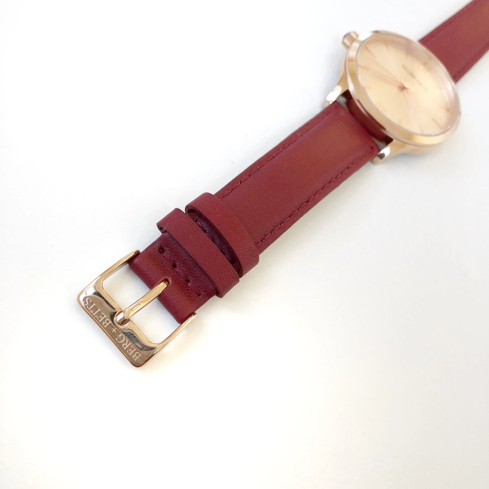 Minimalistic round rose gold watch ethically made with burgundy strap made from recycled leather